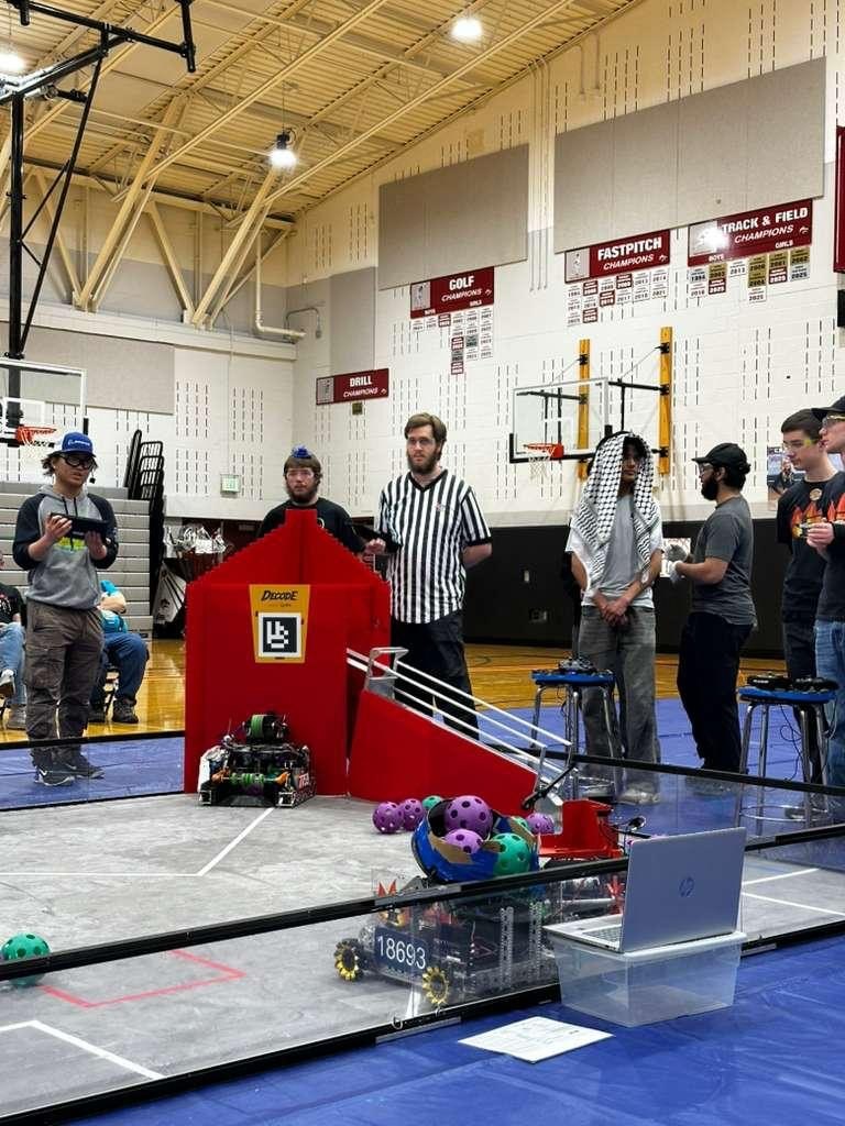 DECODE competition field with robots and a referee