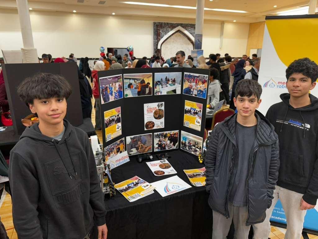 Students at a community table with a trifold and join flyers