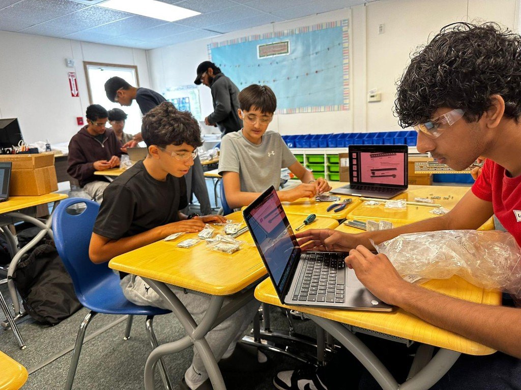 Students coding and sorting parts during a shop night