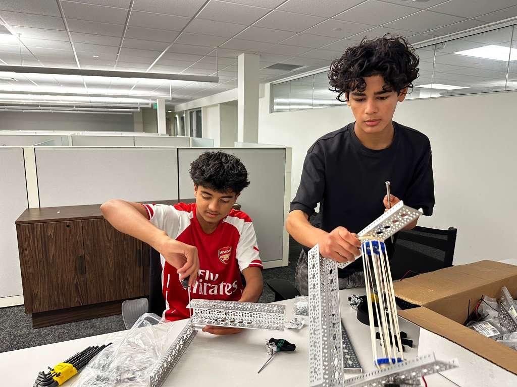 Students assembling a metal frame with hand tools